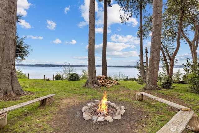 view of yard featuring a water view and an outdoor fire pit