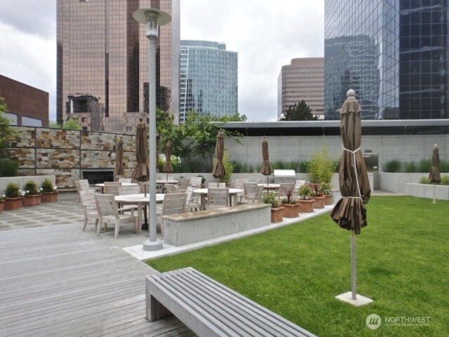 500 106th Ave NE Unit 1803, Bellevue, WA 98004 - view of community featuring a lawn, a city view, outdoor dining space, and a wooden deck