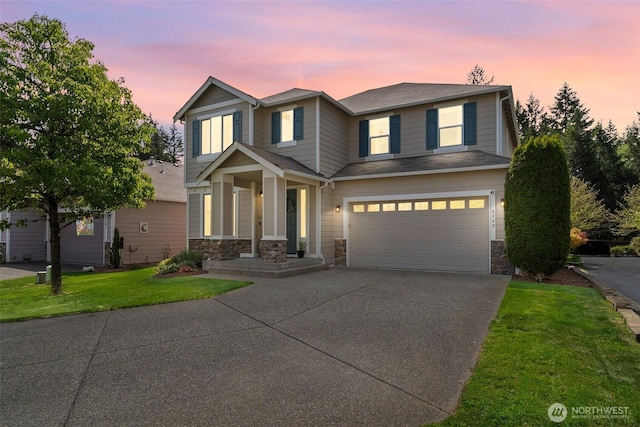 view of front facade with concrete driveway, stone siding, an attached garage, and a yard