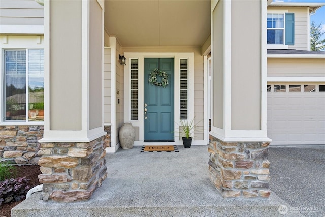 doorway to property featuring stone siding and a garage