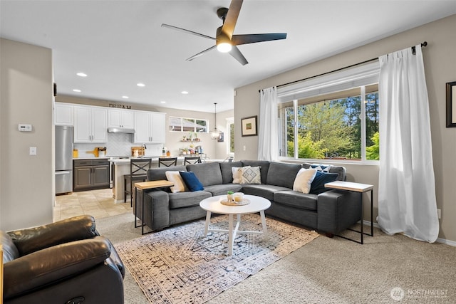 living room with a ceiling fan, recessed lighting, light carpet, and baseboards