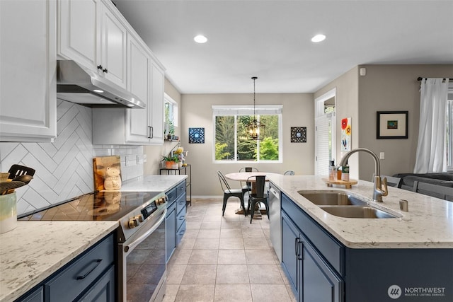 kitchen featuring under cabinet range hood, a sink, blue cabinets, stainless steel appliances, and recessed lighting