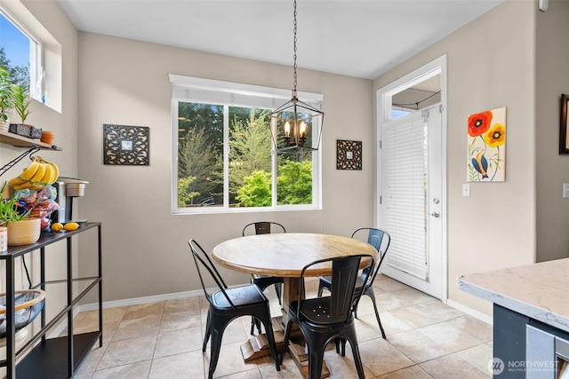 dining area featuring healthy amount of natural light, a chandelier, baseboards, and light tile patterned flooring