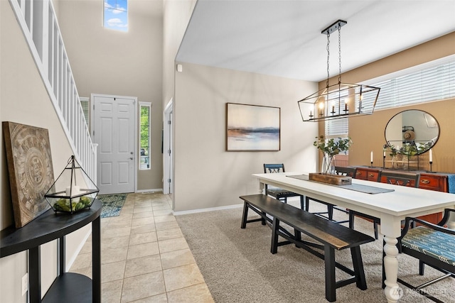 dining area with light tile patterned floors, a chandelier, and baseboards