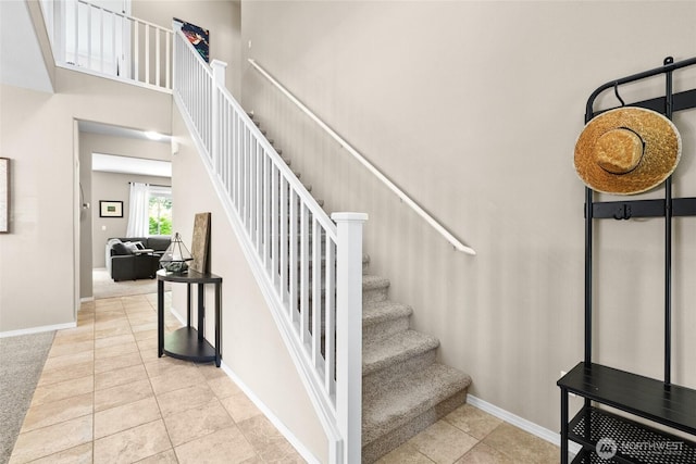 stairs featuring baseboards and tile patterned flooring