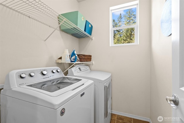 laundry area featuring separate washer and dryer, baseboards, and tile patterned floors