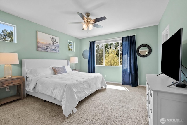 bedroom with light carpet, baseboards, and a ceiling fan