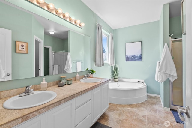 full bath with a shower stall, double vanity, a bath, and baseboards