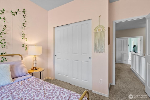bedroom with carpet flooring, baseboards, and a closet