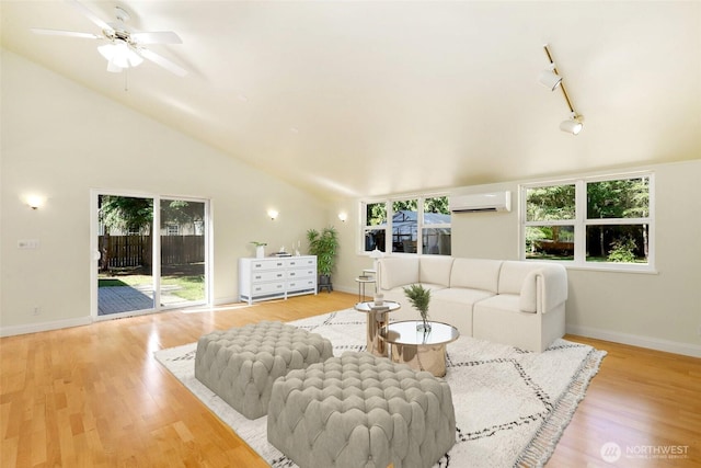 85 Plum Ave, Chimacum, WA 98325 - living room featuring vaulted ceiling, a wall mounted air conditioner, light wood-style floors, baseboards, and a ceiling fan