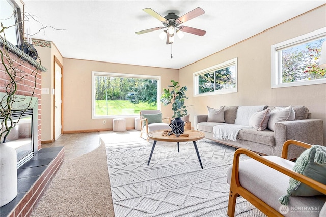 living area with a healthy amount of sunlight, baseboards, a ceiling fan, and carpet floors