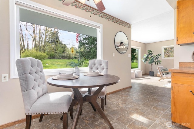 dining room with stone finish flooring, baseboards, and ceiling fan
