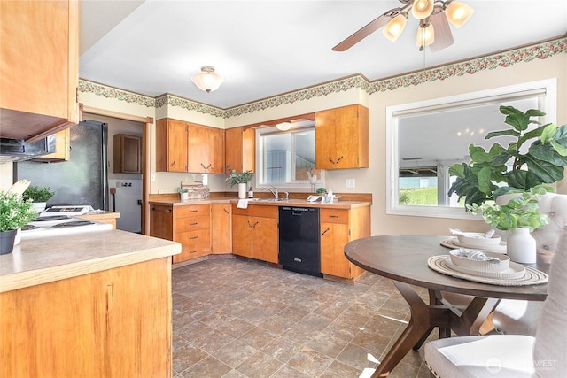 kitchen featuring light countertops, a ceiling fan, black appliances, stone finish floor, and a sink
