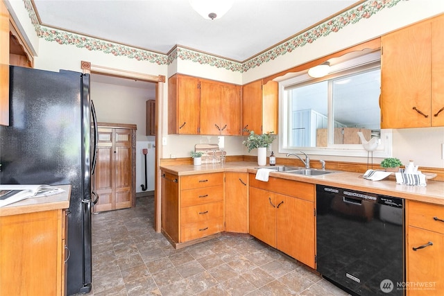 kitchen with stone finish flooring, light countertops, a sink, and black appliances