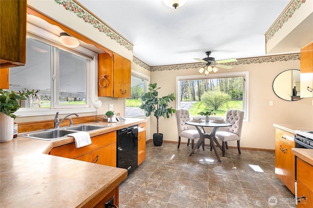 kitchen featuring baseboards, dishwasher, a sink, light countertops, and ceiling fan