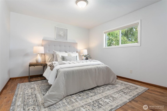 bedroom with wood finished floors and baseboards