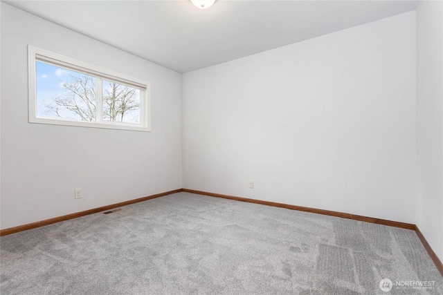 unfurnished room with baseboards, visible vents, and carpet floors