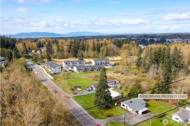aerial view with a wooded view and a mountain view