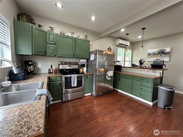 kitchen with green cabinets, appliances with stainless steel finishes, a wall unit AC, and a sink