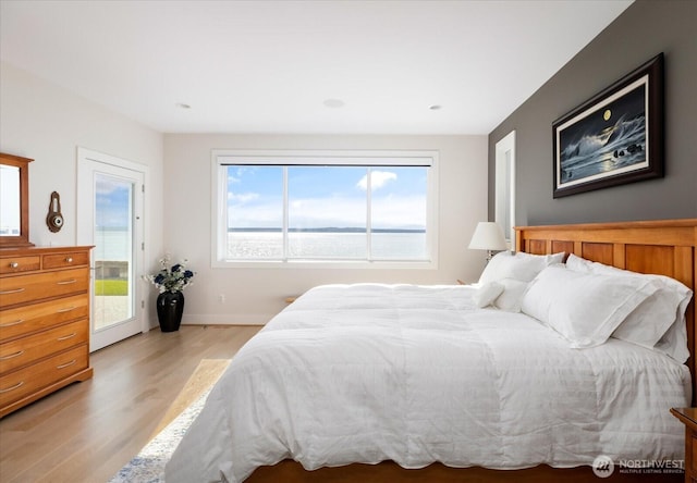 bedroom with light wood-style flooring, access to exterior, and baseboards