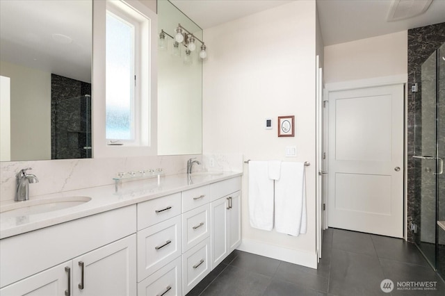 bathroom with a shower stall, double vanity, and a sink