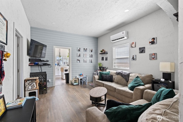 411W 1st Ave, Kennewick, WA 99336 - living area with a textured ceiling, a wall mounted air conditioner, a textured wall, and hardwood / wood-style flooring