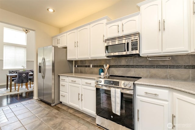 19204 Evergreen Dr, Bonney Lake, WA 98391 - kitchen with appliances with stainless steel finishes, backsplash, and white cabinets