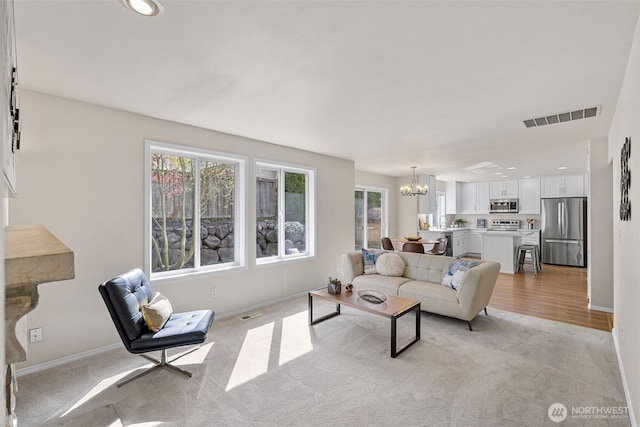 living area with recessed lighting, light colored carpet, a chandelier, baseboards, and visible vents