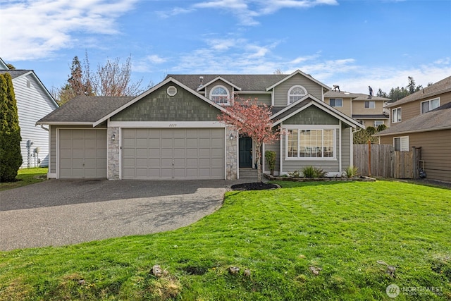 traditional-style home with driveway, roof with shingles, fence, a front lawn, and a garage