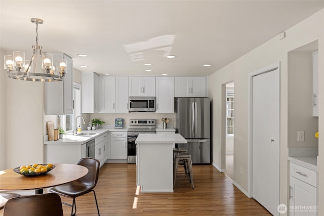 kitchen featuring light wood-style flooring, a sink, appliances with stainless steel finishes, and light countertops