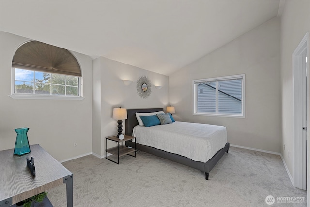 bedroom featuring vaulted ceiling, light carpet, and baseboards