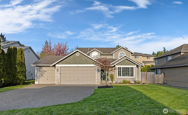 view of front of house featuring a garage, fence, a front yard, and driveway