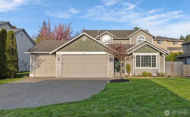 view of front of home with fence, a front yard, driveway, and an attached garage