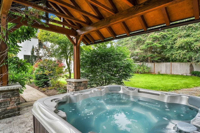 view of patio featuring fence and a hot tub