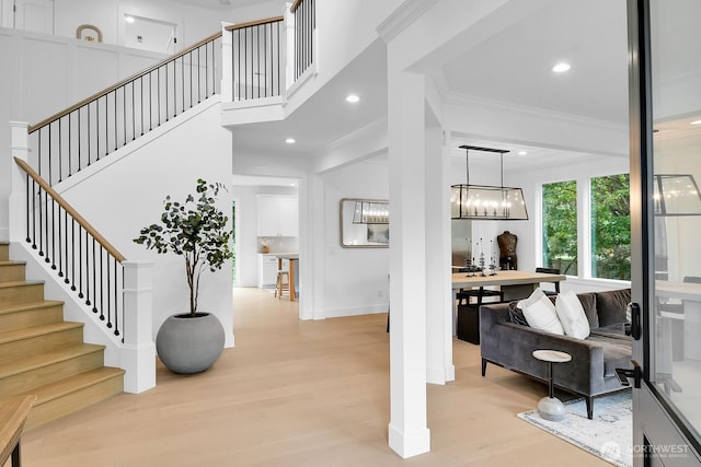 stairway featuring ornamental molding, recessed lighting, a chandelier, and wood finished floors
