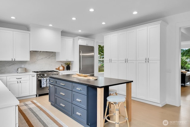 kitchen with high quality appliances, white cabinetry, recessed lighting, decorative backsplash, and blue cabinets