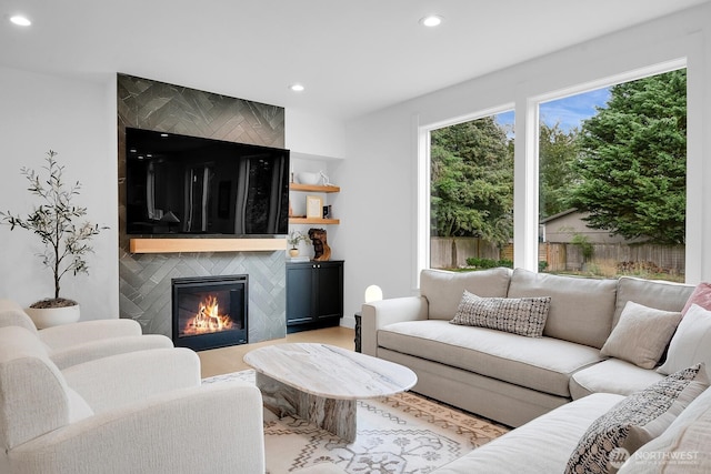living room with light wood finished floors, a fireplace, and recessed lighting
