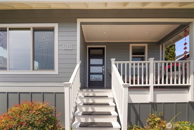 view of exterior entry featuring covered porch