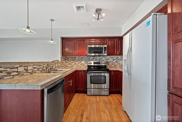 kitchen with visible vents, a sink, dark brown cabinets, stainless steel appliances, and tile countertops