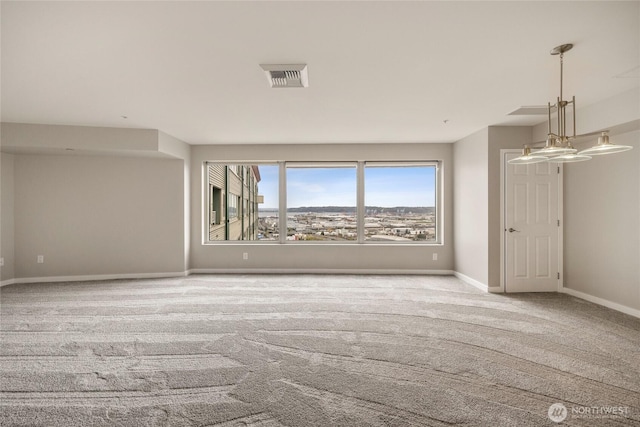carpeted spare room with baseboards and visible vents