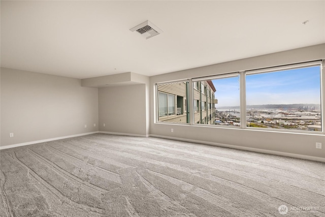 carpeted empty room with visible vents and baseboards