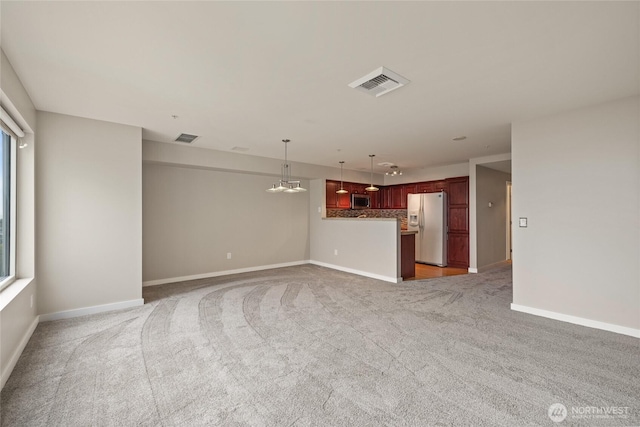 unfurnished living room featuring visible vents, baseboards, and light carpet