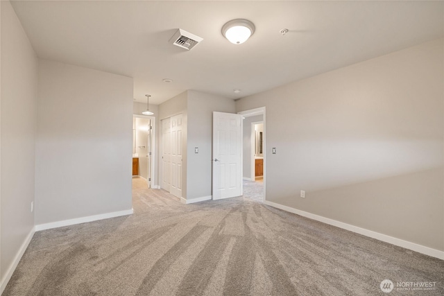 empty room featuring visible vents, baseboards, and light carpet