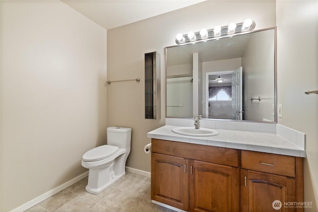 full bath featuring toilet, tile patterned floors, vanity, and baseboards
