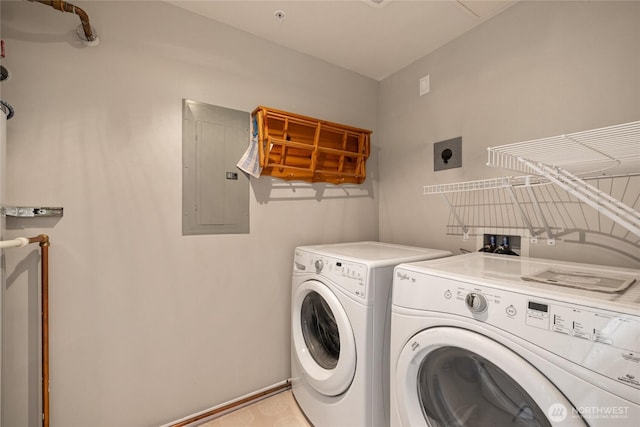 washroom featuring laundry area, washing machine and dryer, baseboards, and electric panel