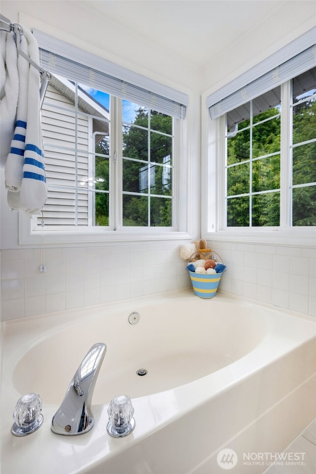 full bath with healthy amount of natural light and a bath
