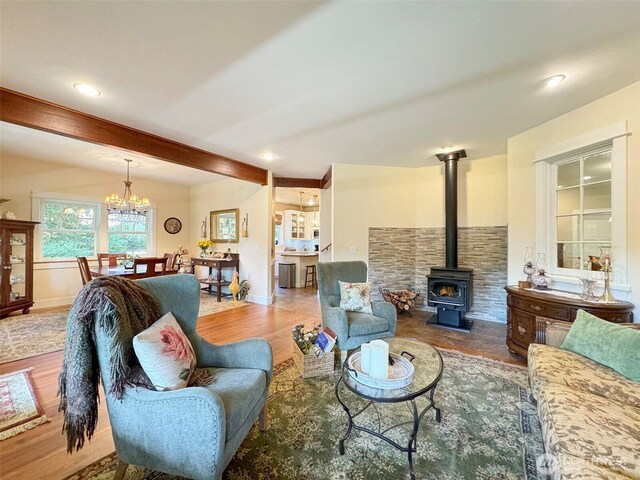 325 Evergreen View Pkwy, Port Angeles, WA 98363 - living area with beam ceiling, a wood stove, an inviting chandelier, and wood finished floors
