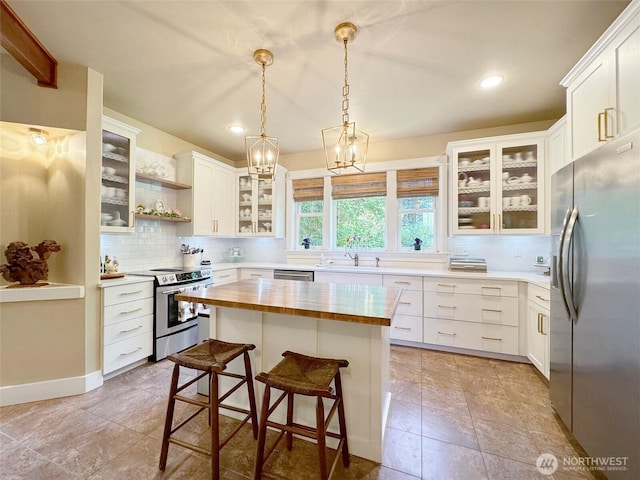 325 Evergreen View Pkwy, Port Angeles, WA 98363 - kitchen with a kitchen bar, wooden counters, backsplash, and stainless steel appliances