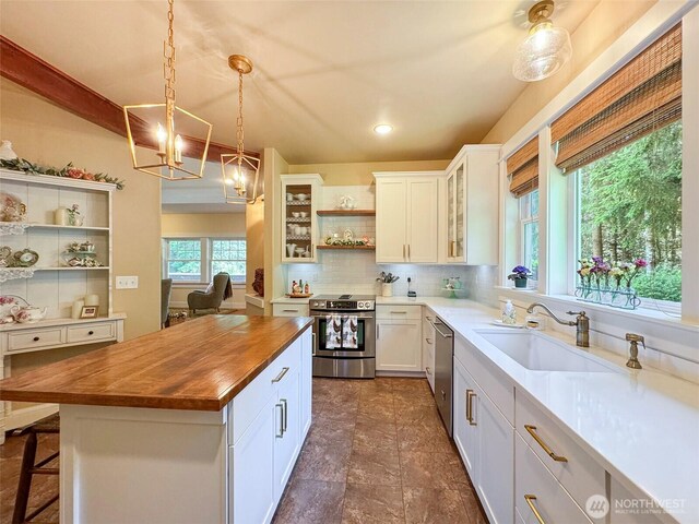 325 Evergreen View Pkwy, Port Angeles, WA 98363 - kitchen featuring appliances with stainless steel finishes, open shelves, wooden counters, decorative backsplash, and a sink