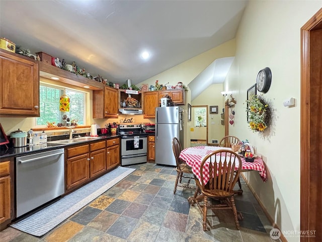 325 Evergreen View Pkwy, Port Angeles, WA 98363 - kitchen with a sink, dark countertops, appliances with stainless steel finishes, brown cabinets, and vaulted ceiling
